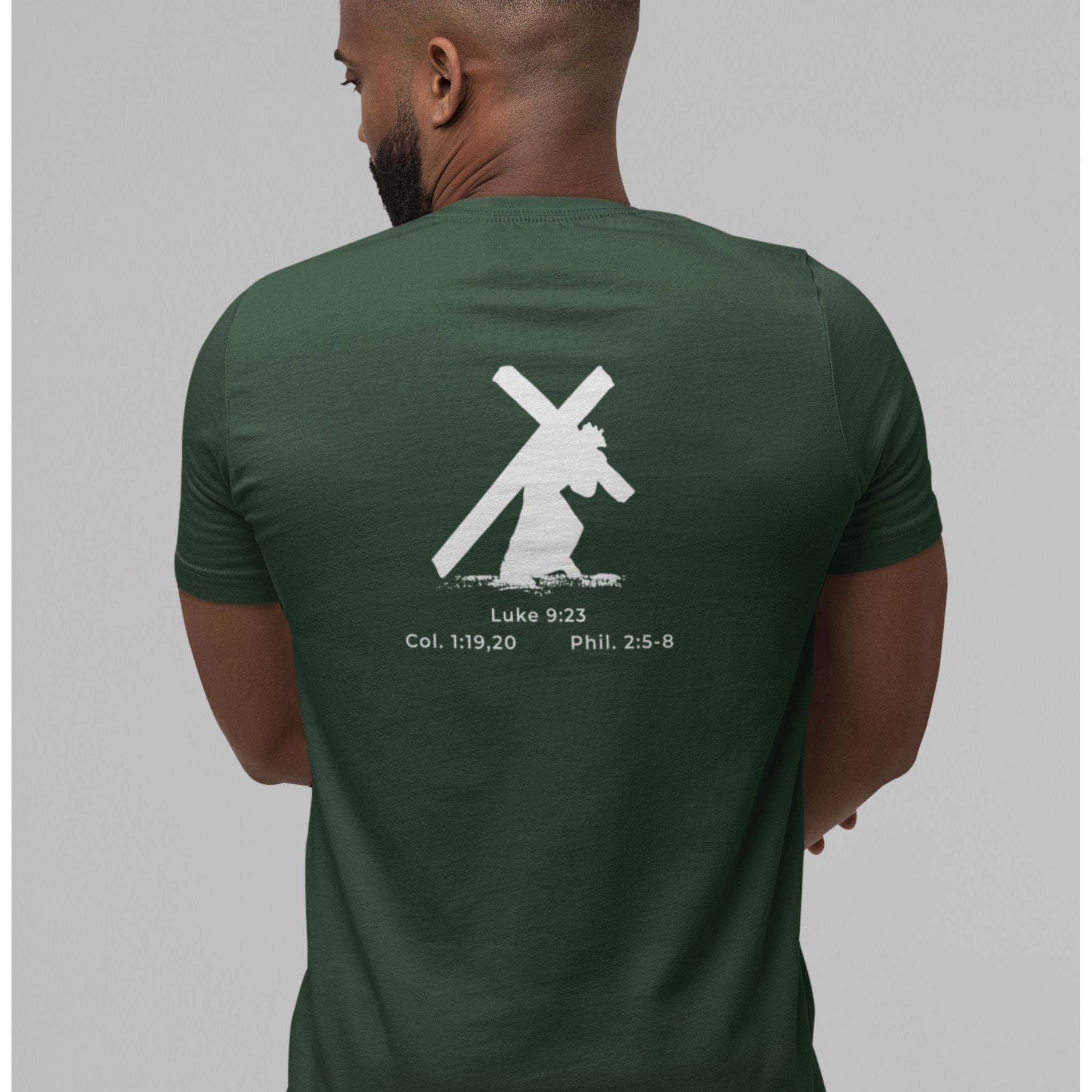 Man wearing a green t-shirt with a white graphic and text on the back, standing against a gray background.