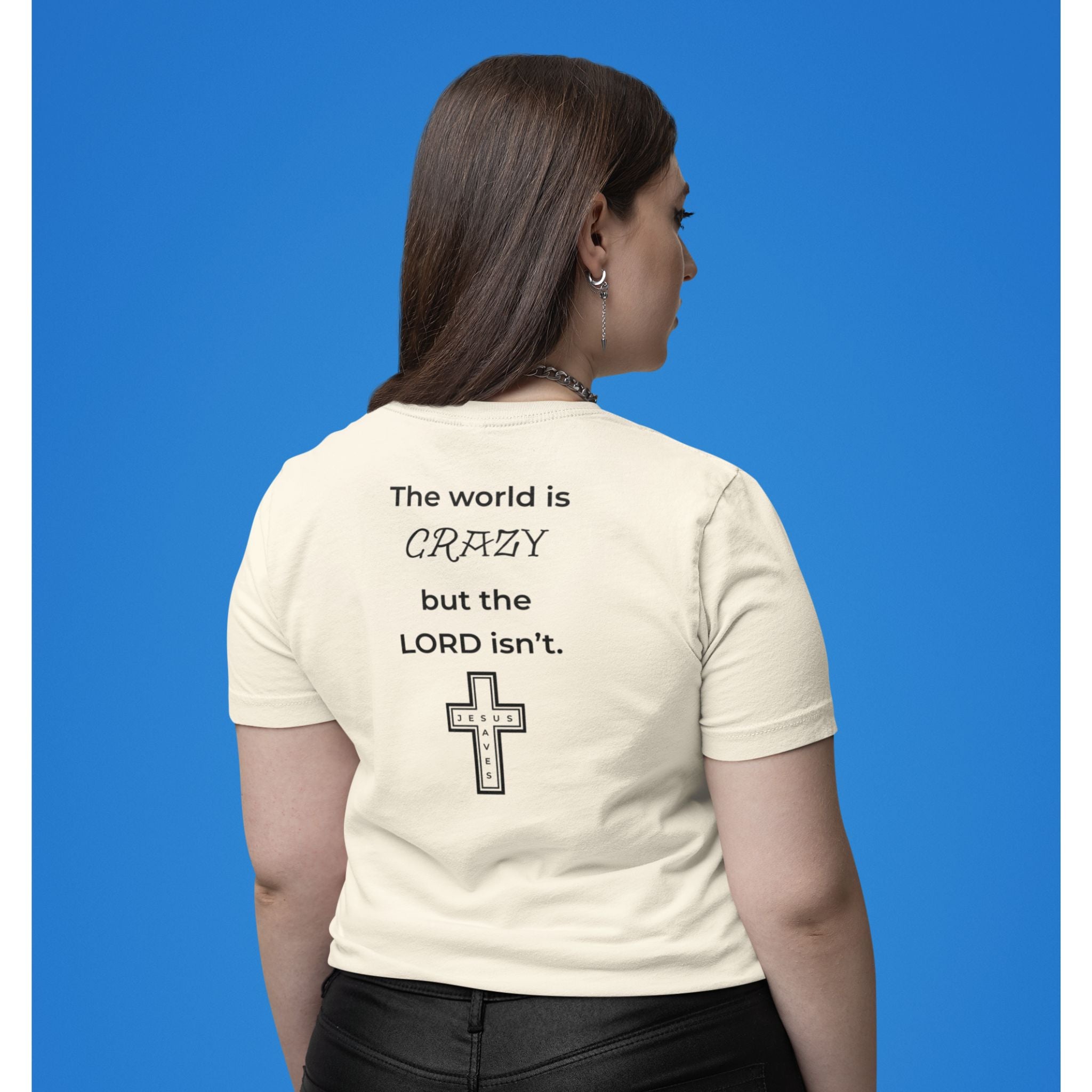 Back view of a natural-colored t-shirt with a black text design reading “The world is crazy but the Lord isn’t” and a small Jesus Saves cross detail.