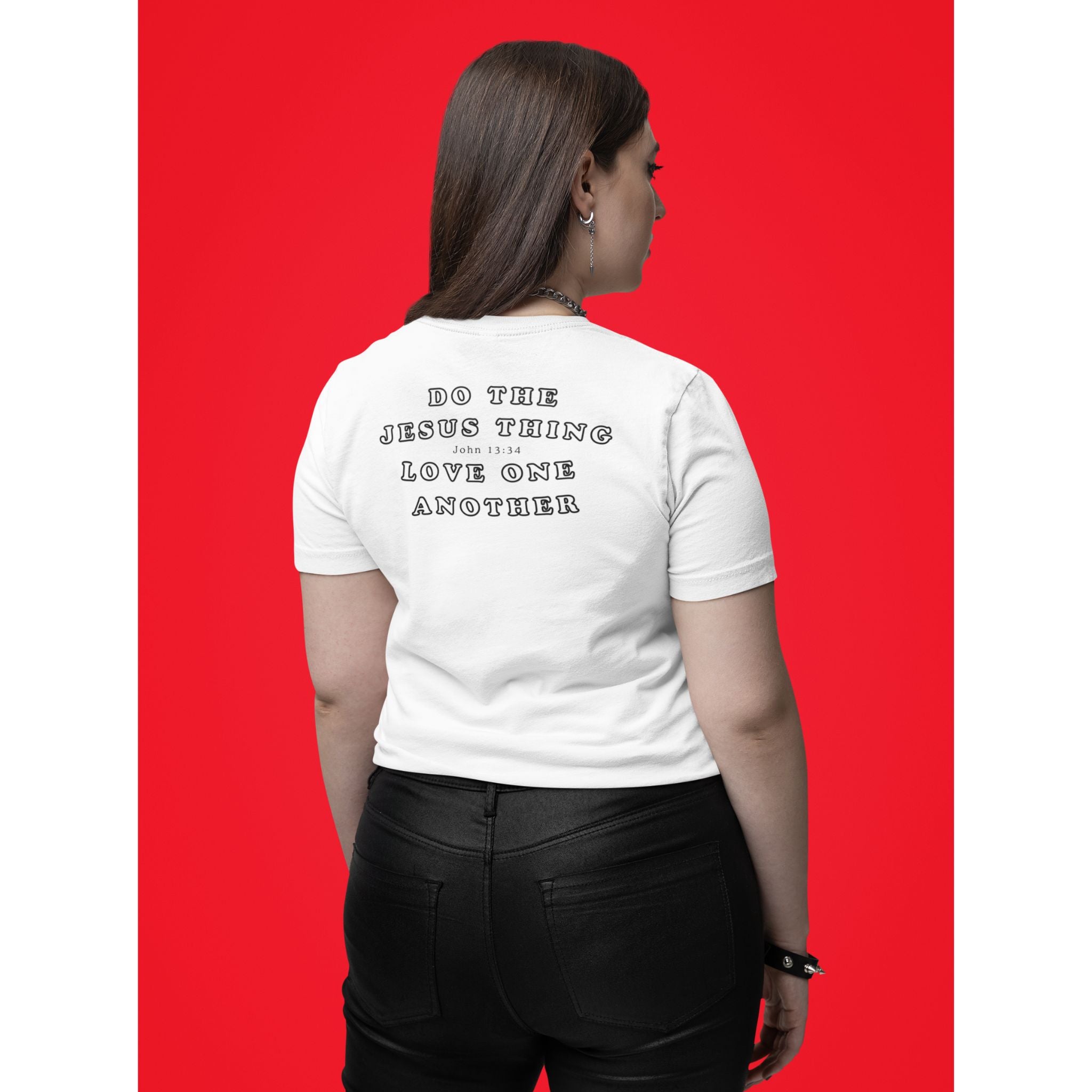 A woman shown from the back wearing a white short-sleeve t-shirt with black text that reads 'DO THE JESUS THING LOVE ONE ANOTHER' on a solid red background.
